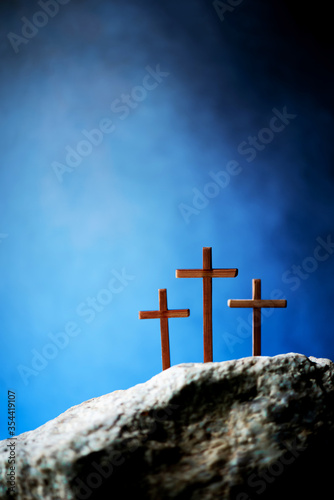 Canvas Print Three wooden cross on Calvary hill, blue background