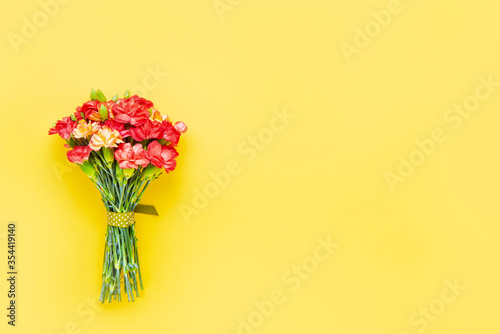 Red carnation flowers bouquet on yellow background. Mother s day  Valentines Day  Birthday celebration concept. Copy space  top view