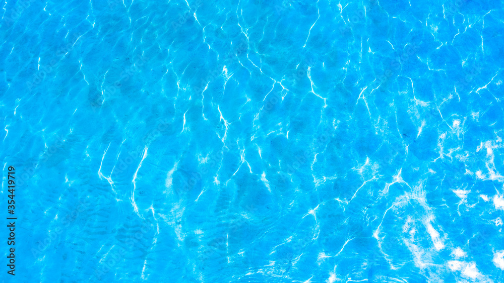 Blue background, texture of water surface with sunlight reflections