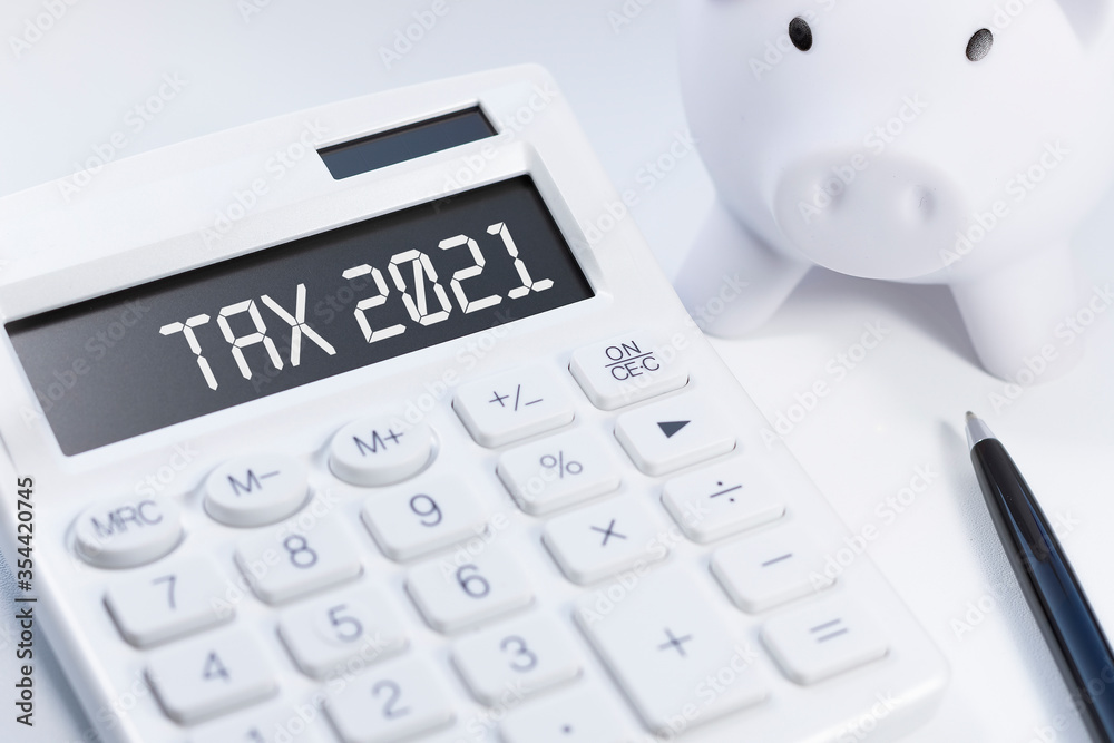 Word Tax 2021 on calculator. Business and tax concept on white background. Top view. Word Tax 2021 on calculator. Business and tax concept on white background. Top view.