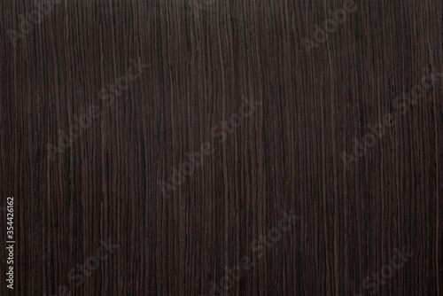 Vertical natural texture of dark brown wood veneer.