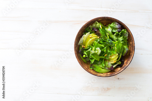 Mix salad leaves, green peas and green apples in a bowl
