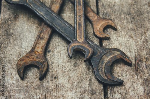 Rusty wrenches on a wooden background. Old keys