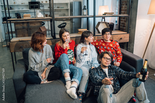 Group friends talking sitting in a couch in the living room