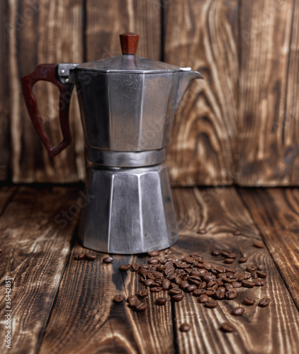 Steamed Moka pot with coffee beans on a dark wood table vintage photo