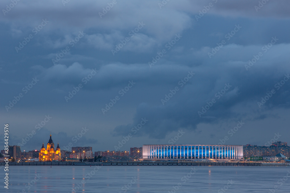 Nizhny Novgorod. The original view of the city, arrow, stadium and Alexander Nevsky Cathedral in the evening with the lights of the night city and a lead sky