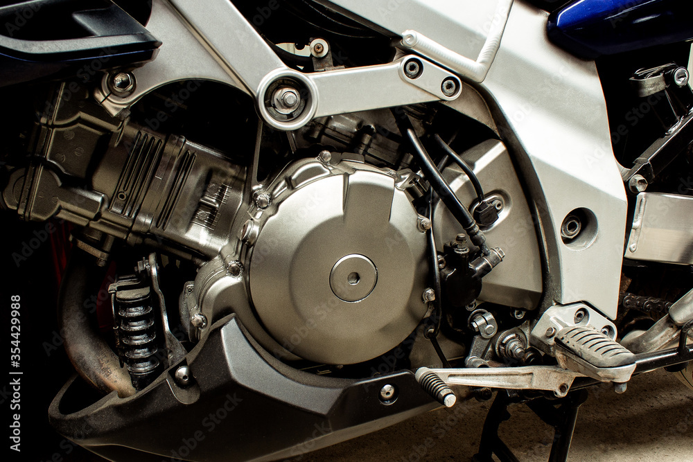 Silver engine of a sports motorcycle closeup. Chain, gear motorbike