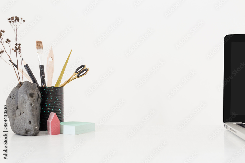 Creative desk with a blank picture frame or poster, desk objects, office supplies, books, and plant on a dark blue background.
Creative desk with a blank picture frame or poster, desk objects, office supplies, books, and plant on a dark blue background.