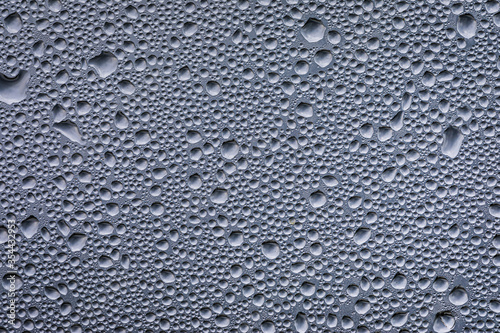 Drops of water after the rain on a glass panel with the sky above