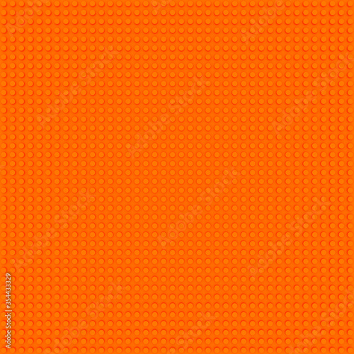 orange base template of plastic construction brick. Plastic toy blocks background in orange. Construction plate base for children's toys. Repeating texture and empty field for bricks installation