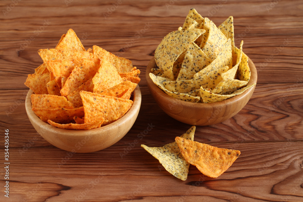 Tortilla chips nachos’ Mexican and tortilla chips with chia seeds in bamboo bowls on wooden table. Closeup