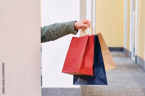 Woman holding in hand shopping package. Paper bag. Sale in store. Beautiful young girl after shopping in fashion shop. Customer buy present online. Black friday sale. Holiday special offer, discount
