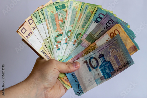 Hands with Belarusian money on a white background. Belarusian currency on a white background