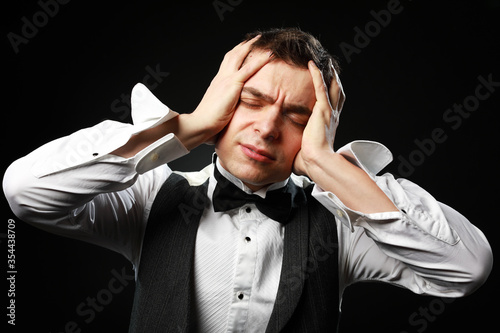 Portrait of a young and handsome man with emotion and funny face in black bow-tie isolated on black background.with copy space. 