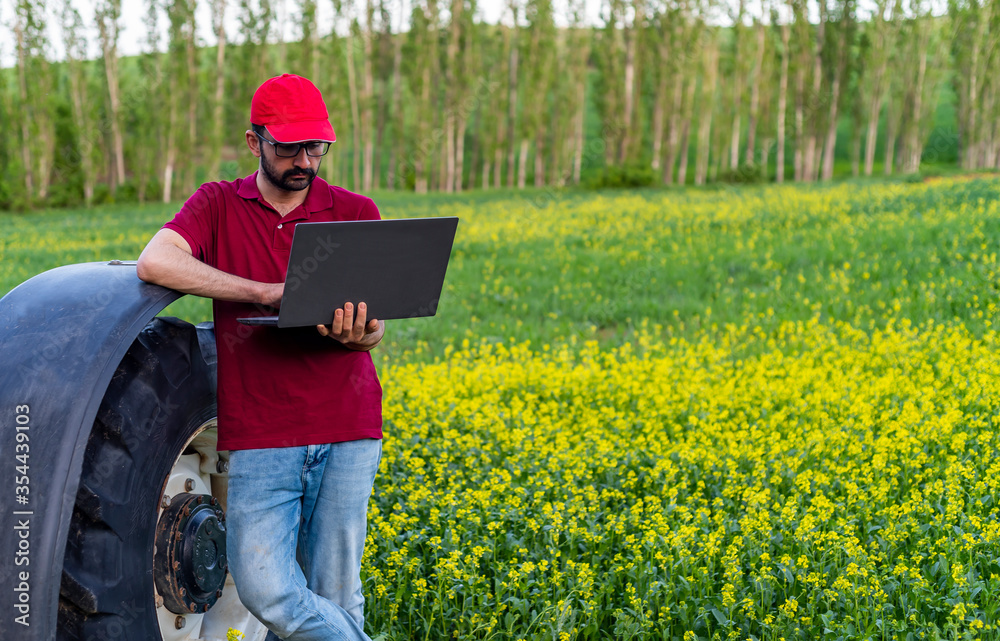 Smart farming, using modern technologies in agriculture. Man agronomist farmer with digital tablet computer in field using apps and internet of things(IOT) in production and agricultural research Smart farming, using modern technologies in agriculture. Man agronomist farmer with digital tablet computer in field using apps and internet of things(IOT) in production and agricultural research