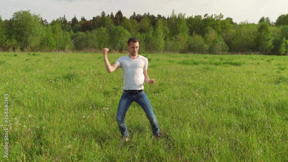 Happy man dancing and jumping in the summer on the field. nature, crazy jumping and fooling around. Fool. Happy man dancing and jumping in the summer on the field. nature, crazy jumping and fooling around. Fool.