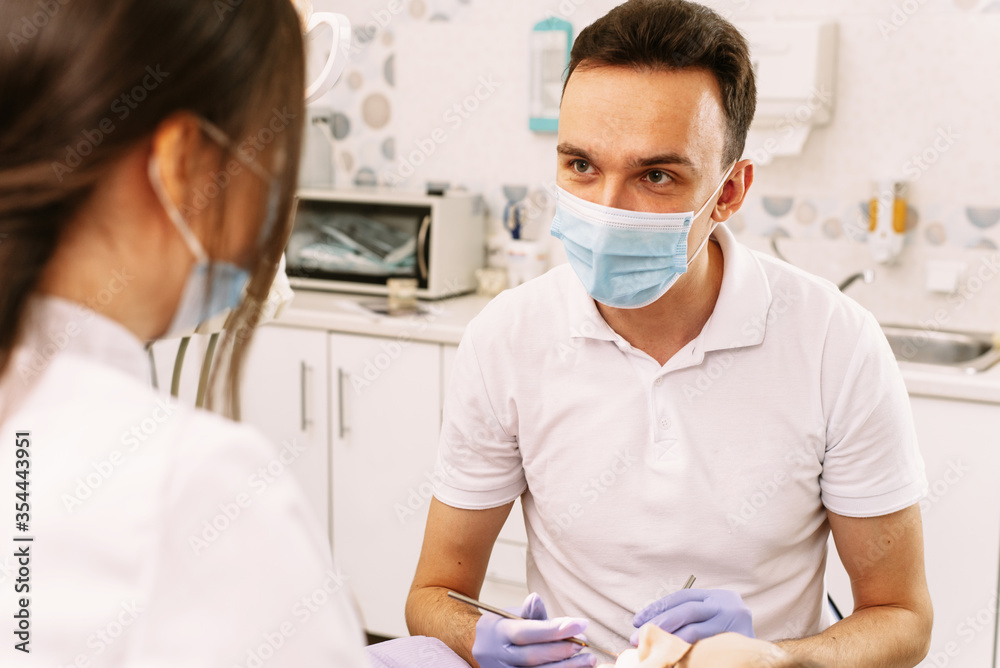 A beautiful girl lies in the dentists chair. The doctor and assistant are treating the patients teeth. Advertising blank A beautiful girl lies in the dentists chair. The doctor and assistant are treating the patients teeth. Advertising blank