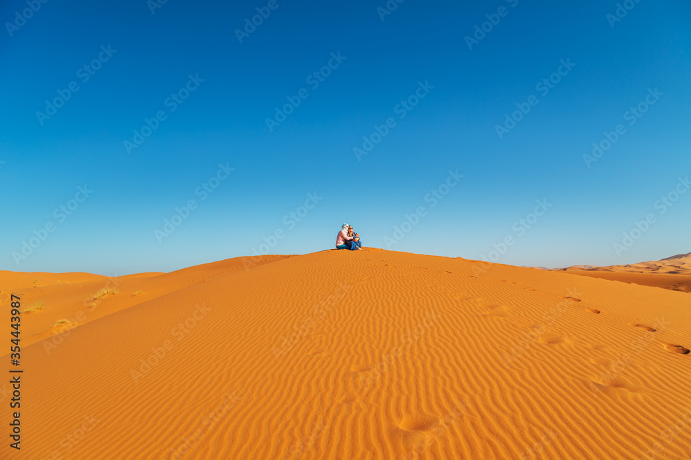 Loving couple in the Sahara desert. Joint rest.