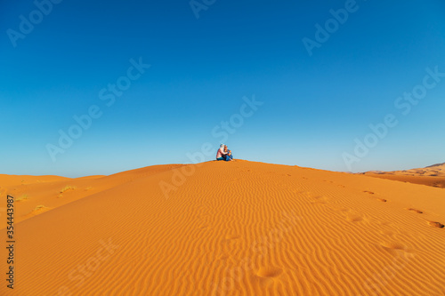 Loving couple in the Sahara desert. Joint rest.