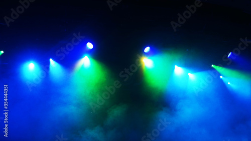 Setting up the stage light before the show. Bright multi-colored rays of spotlights, geometric patterns on a black background. ultraviolet light 4K, blue, violet colors