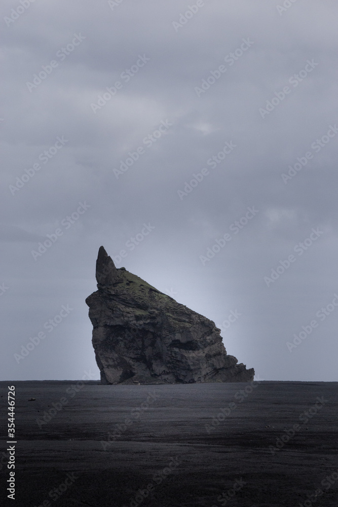 A lone rock on a black sand beach, South Icelnad A lone rock on a black sand beach, South Icelnad