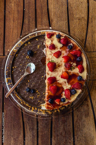 Half delicious cheese cake with small red strawberries