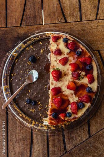 Half delicious cheese cake with small red strawberries