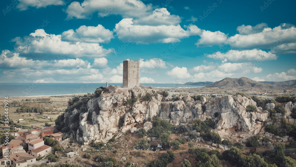 aerial view of tower castle and medieval town with valley and sea - Posada, Sardinia