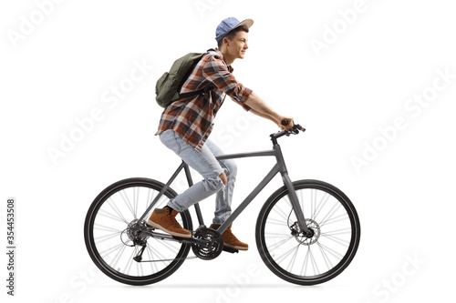 Fototapeta Naklejka Na Ścianę i Meble -  Profile shot of a male student riding a bicycle