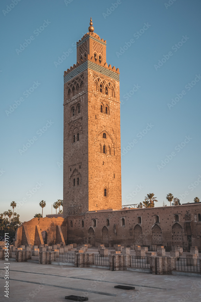Koutoubia Mosque minaret during twilight located at medina quarter of Marrakesh, Morocco, North Africa. Sunset view on a sunny day with blue sky.