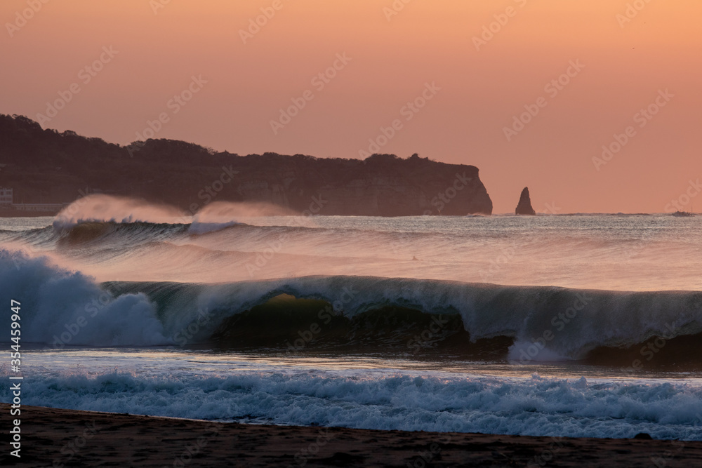 Waves breaking in Japan. The Pacific Ocean & its waves often generated by a Typhoon. The stunning coastline of Japan, Travellers like to visit the beach & watch the swell turn into waves & break