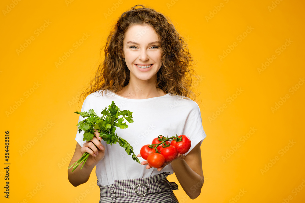 Pretty caucasian girl with curly hair holding vegetables Pretty caucasian girl with curly hair holding vegetables
