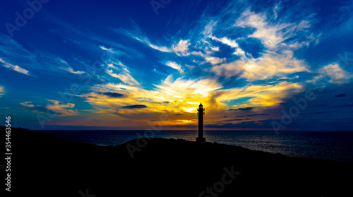 sunset on the Canary coast with a lighthouse and a beautiful sky with clouds with beautiful shapes and beautiful with beautiful colors