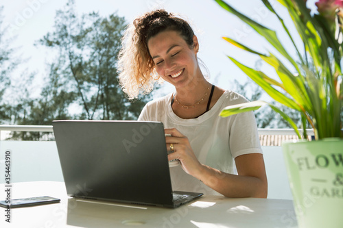 Attractive young woman working at home office with notebook smiling isolated during covid 19 pandemic.
