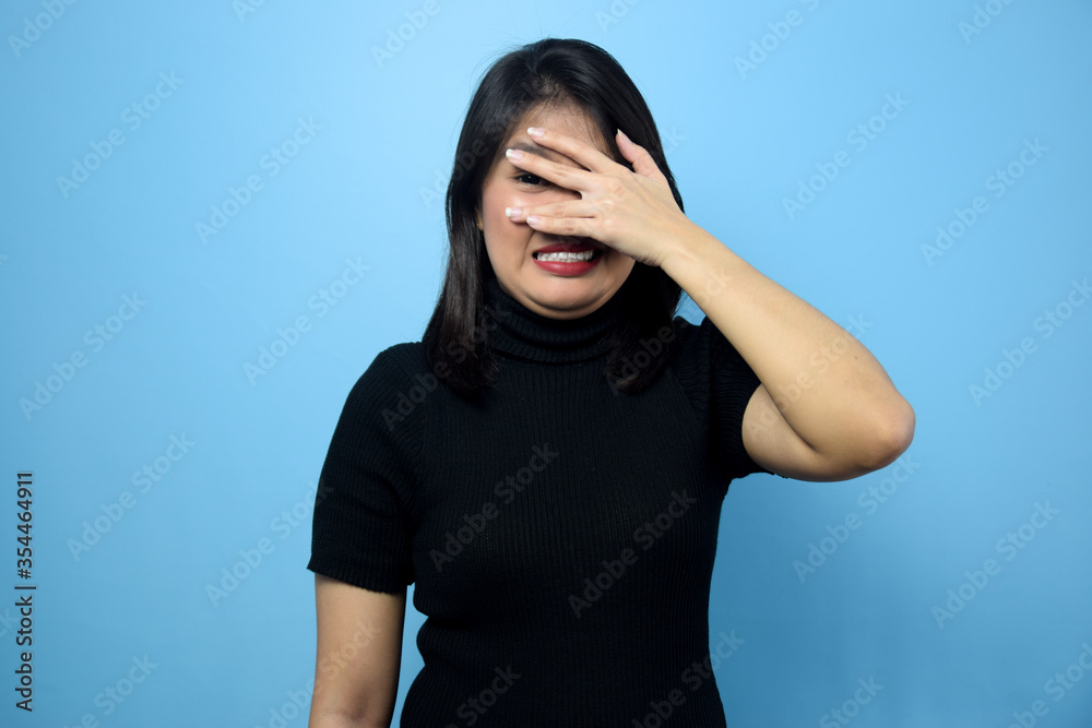 Portrait of Young beautiful asian women wearing black turtle neck shirt with blue isolated background Portrait of Young beautiful asian women wearing black turtle neck shirt with blue isolated background