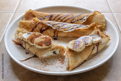 Tasty crepes with cottage cheese and bananas wrapped up and ready for breakfast.