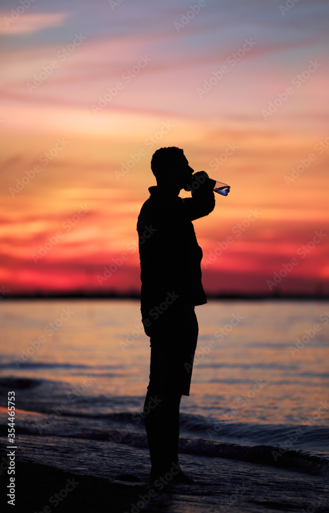 Man drinking water sunset