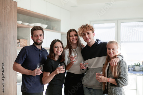 Happy group of friends at home having drinks
