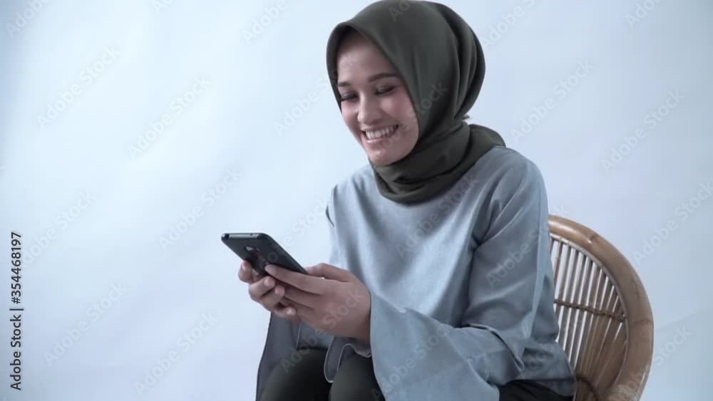 Muslim woman reaction was excited after reading the good news on her cellphone. Muslim woman reaction was excited after reading the good news on her cellphone.
