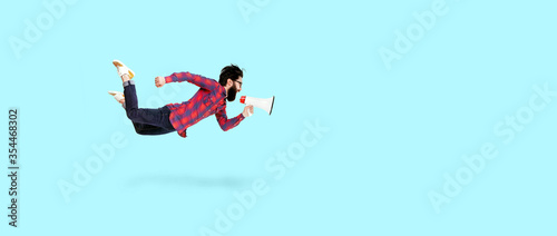 Vászonkép Bearded hipster man in glasses, jumping and shouting in megaphone, photo over bl