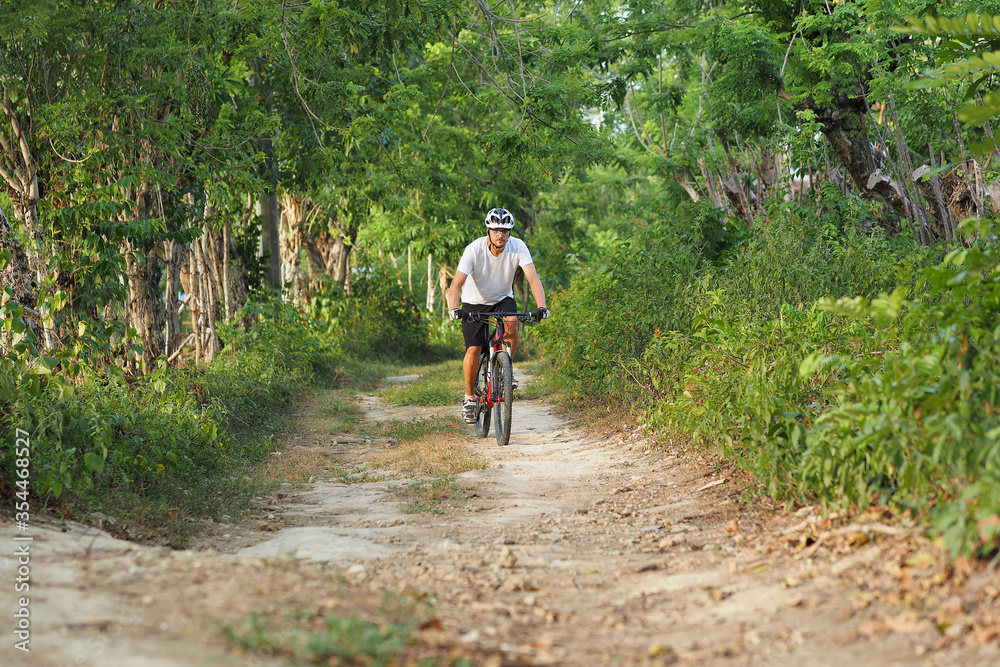 Obraz premium Male on mountain bike riding in summer park.