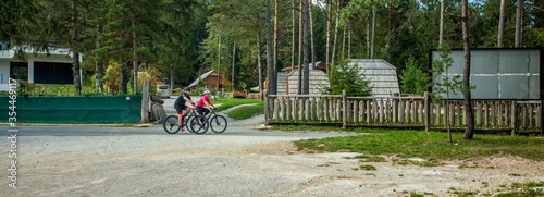 Biker couple biking around a glamping resort at Bloke Lake at Nova Vas, Slovenia photo