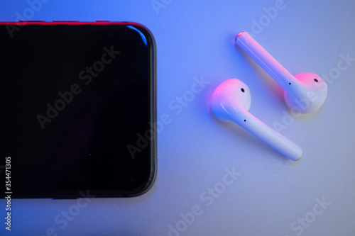 Wireless headphones and phone on a colored background photo