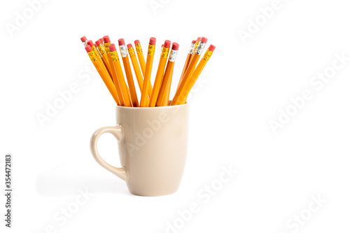 yellow wooden pencils in a coffee cup isolated on white