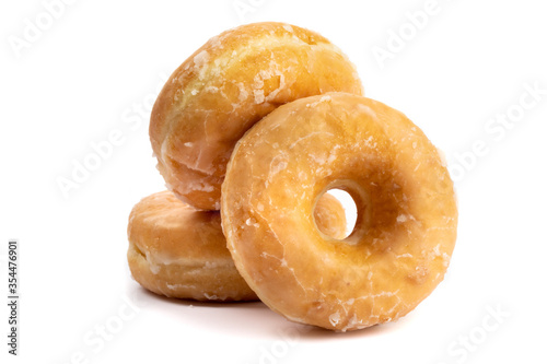 Fotografija three honey dipped donuts in a pile isolated on white