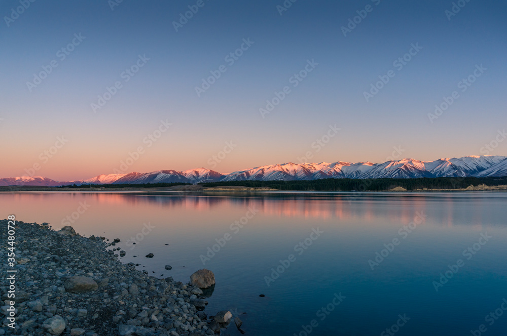 Sunrise winter mountains landscape with calm lake and water reflections