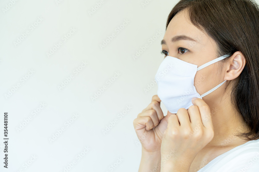 Asian young attractive woman wearing a protective hygiene mask over her face to protect flu and virus. Woman with face mask portrait with copyspace. Covid19 and Coronavirus. Asian young attractive woman wearing a protective hygiene mask over her face to protect flu and virus. Woman with face mask portrait with copyspace. Covid19 and Coronavirus.