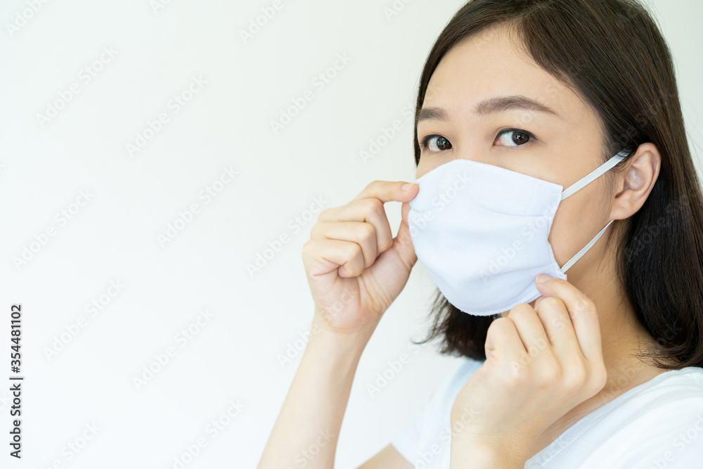 Asian young attractive woman wearing a protective hygiene mask over her face to protect flu and virus. Woman with face mask portrait with copyspace. Covid19 and Coronavirus. Asian young attractive woman wearing a protective hygiene mask over her face to protect flu and virus. Woman with face mask portrait with copyspace. Covid19 and Coronavirus.