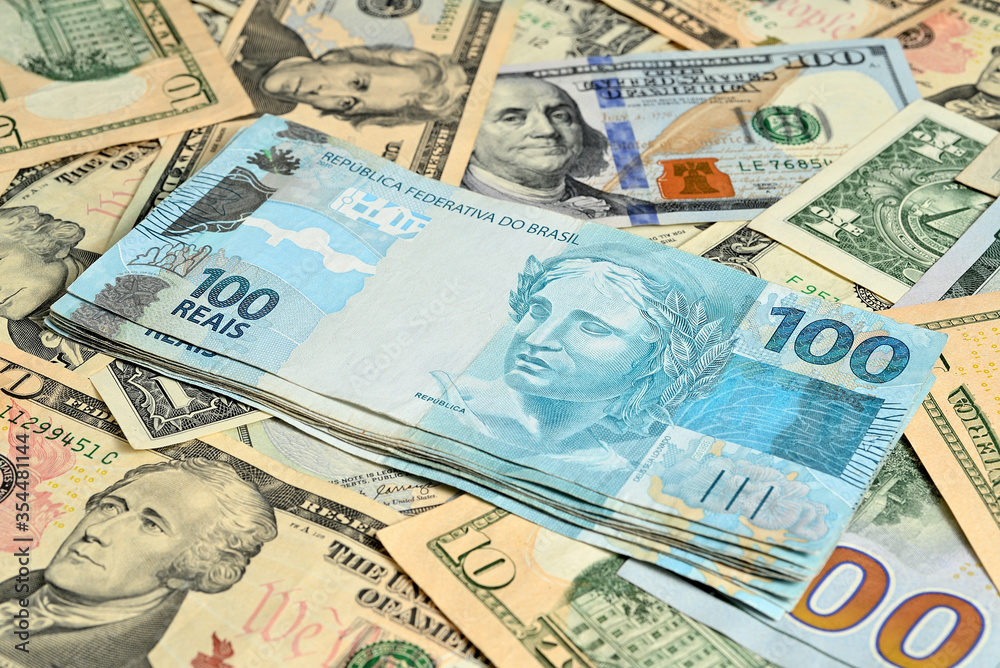 Notas de 100 reais junto com dólares americanos de diversos valores Notas de 100 reais junto com dólares americanos de diversos valores