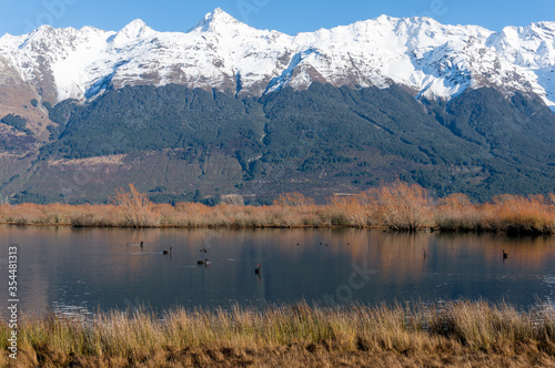 Winter mountain landscape with snow-capped mountains and lake